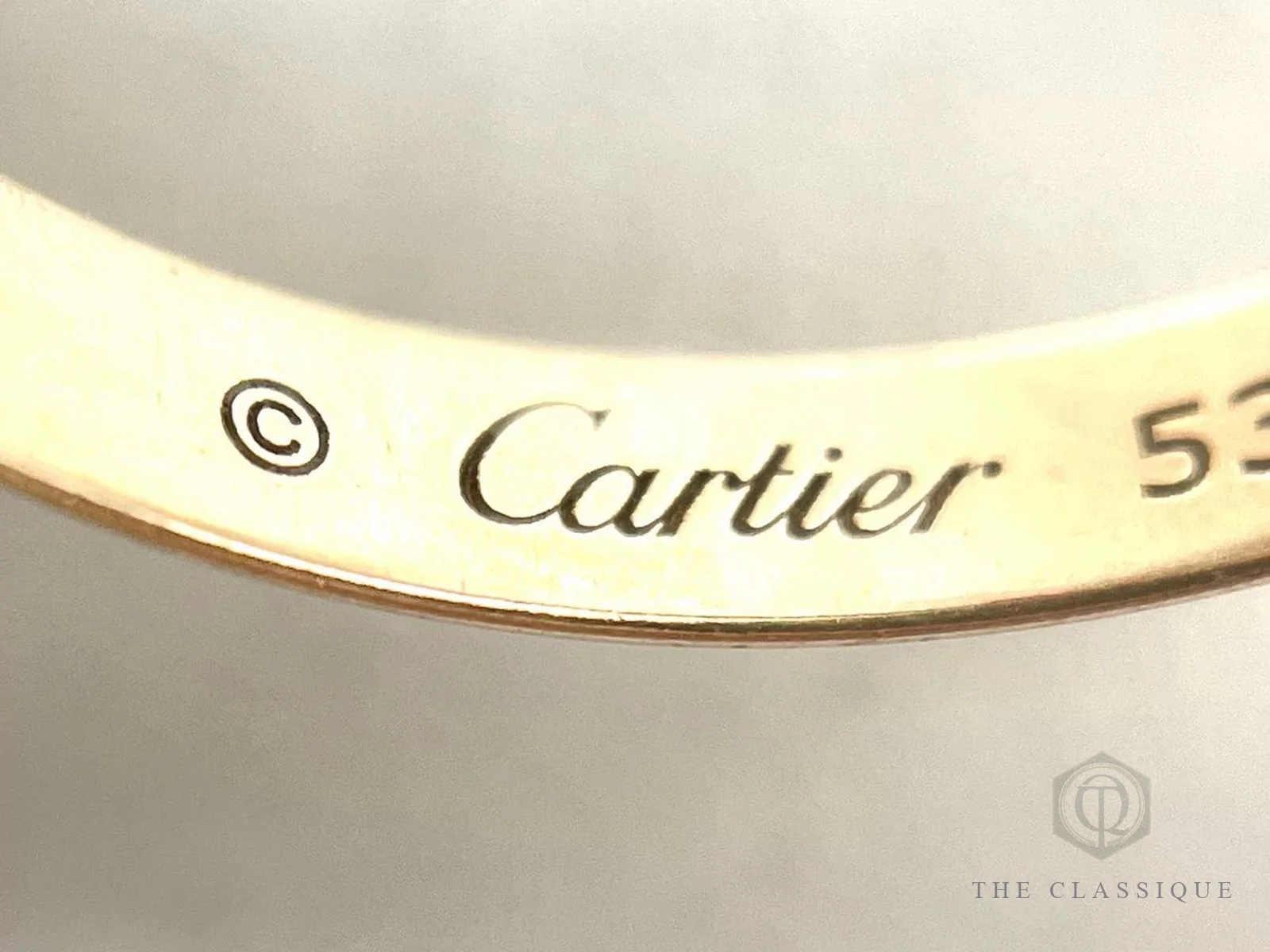Chữ khắc Cartier và số size 53 ở mặt trong một chiếc nhẫn Trinity khi thẩm định trực tiếp