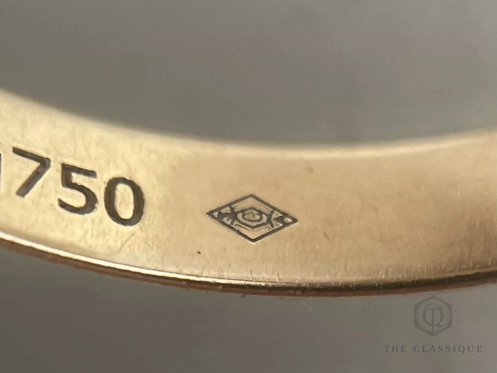 Cận cảnh khắc tuổi vàng 750 và dấu poinçon hình thoi trên thân nhẫn Cartier Trinity