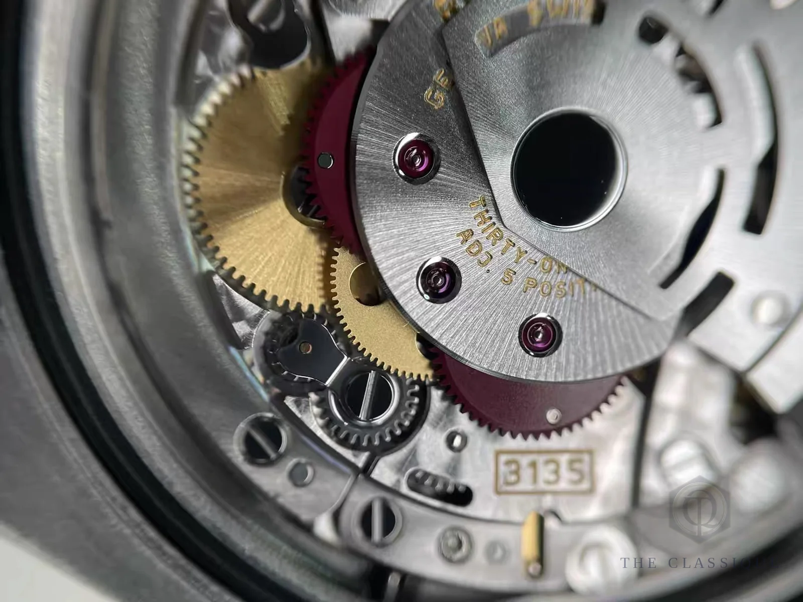 Bộ máy tự động lộ cơ, bánh răng và số hiệu caliber 3135 bên trong một chiếc đồng hồ Rolex, ảnh chụp lúc bên em kiểm định