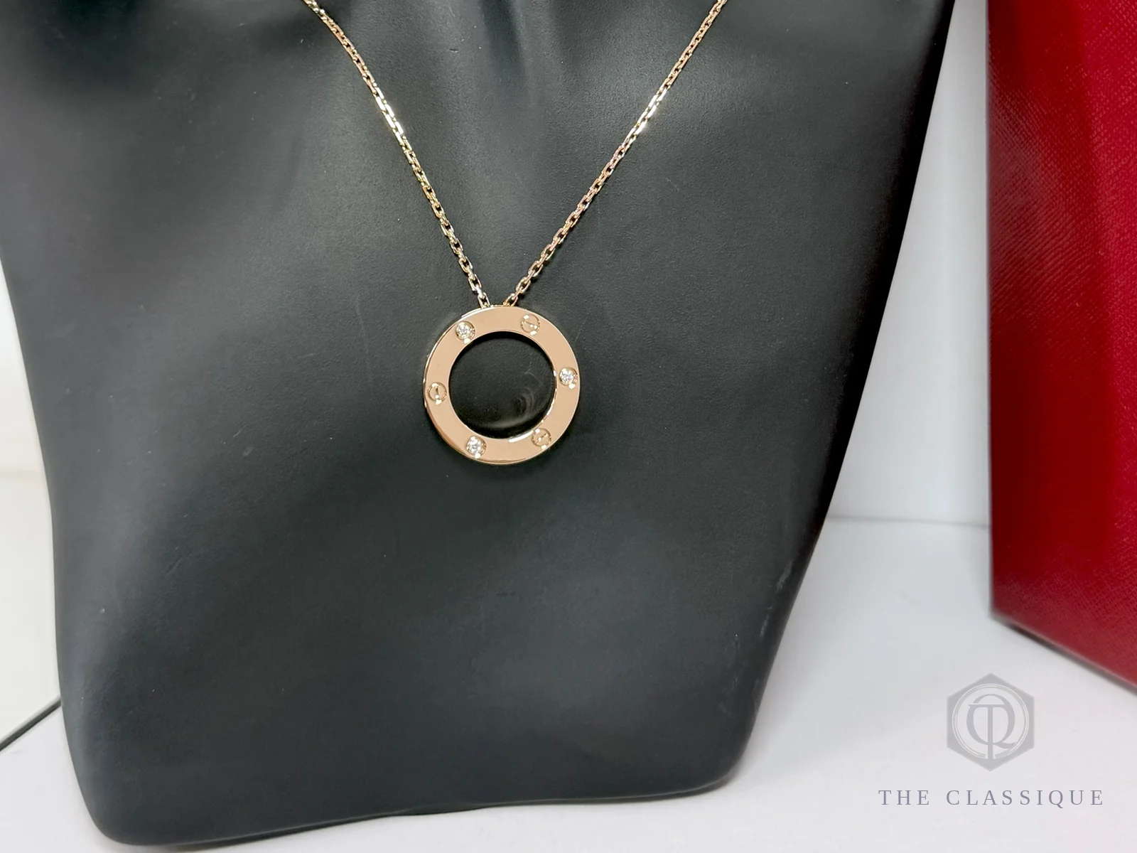 Dây chuyền Cartier Love đeo trên cổ, mặt dây tròn đính bốn viên kim cương nhỏ ở các đầu vít