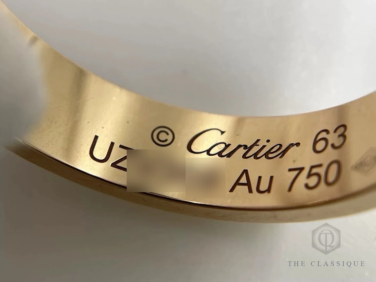 Chữ khắc Cartier, số size 63 và ký hiệu Au 750 mặt trong nhẫn Cartier Love đã qua sử dụng