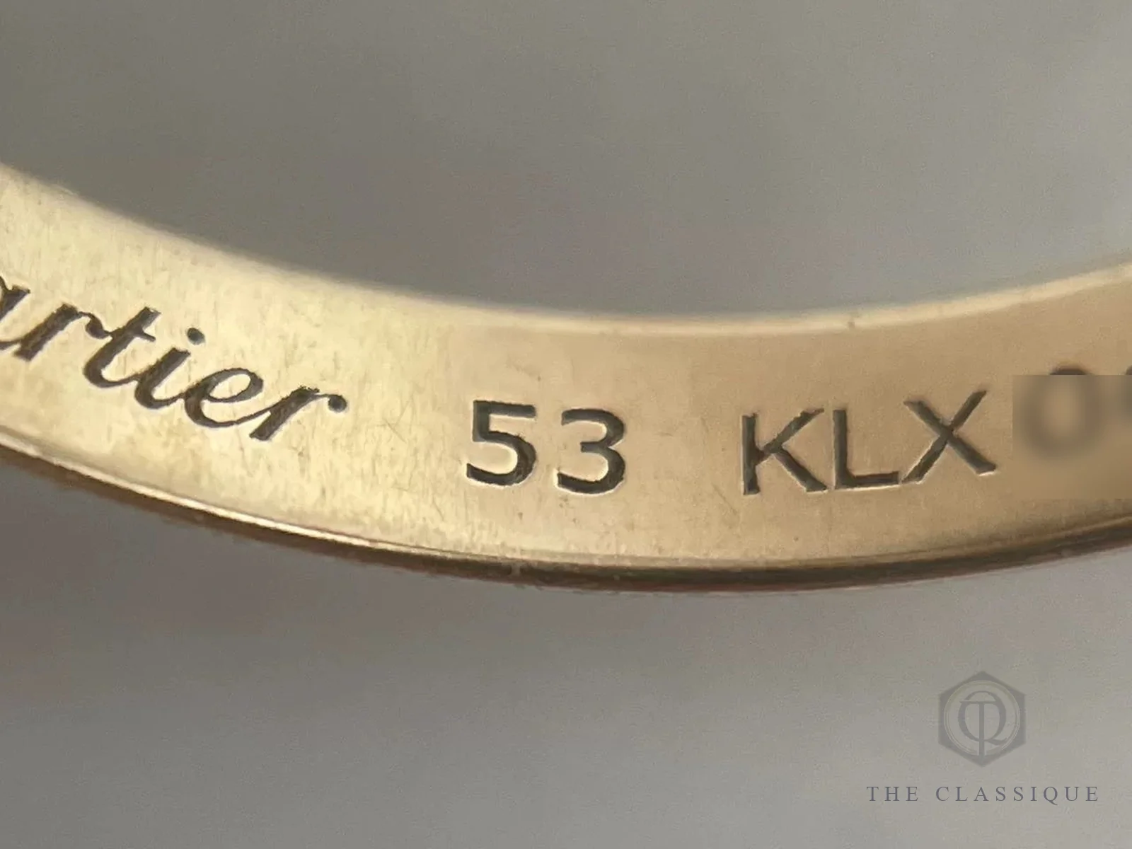 Mặt trong một vòng của nhẫn Cartier Trinity khắc Cartier, size 53 và phần đầu serial ba chữ cái, phần số đã che