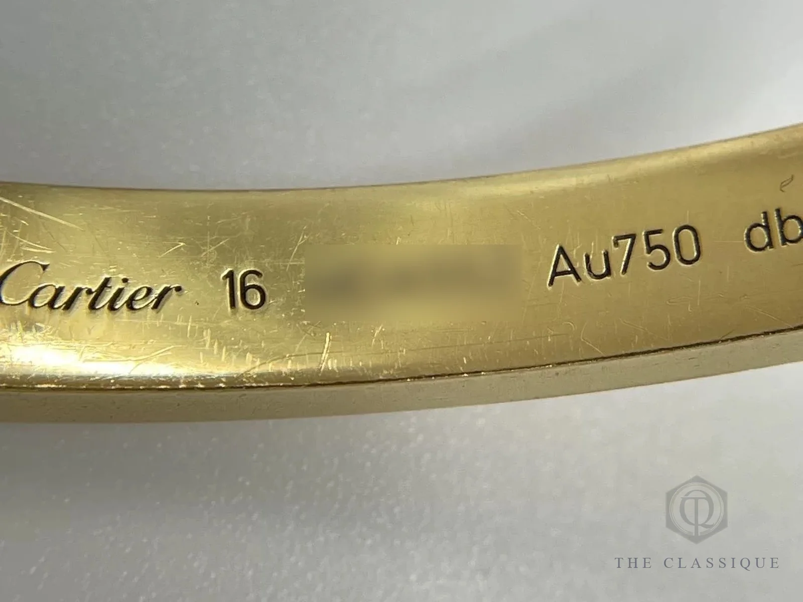 Chữ khắc Cartier, size 16 và Au750 mặt trong vòng Love vàng, thấy rõ các vết trầy nhỏ do đeo