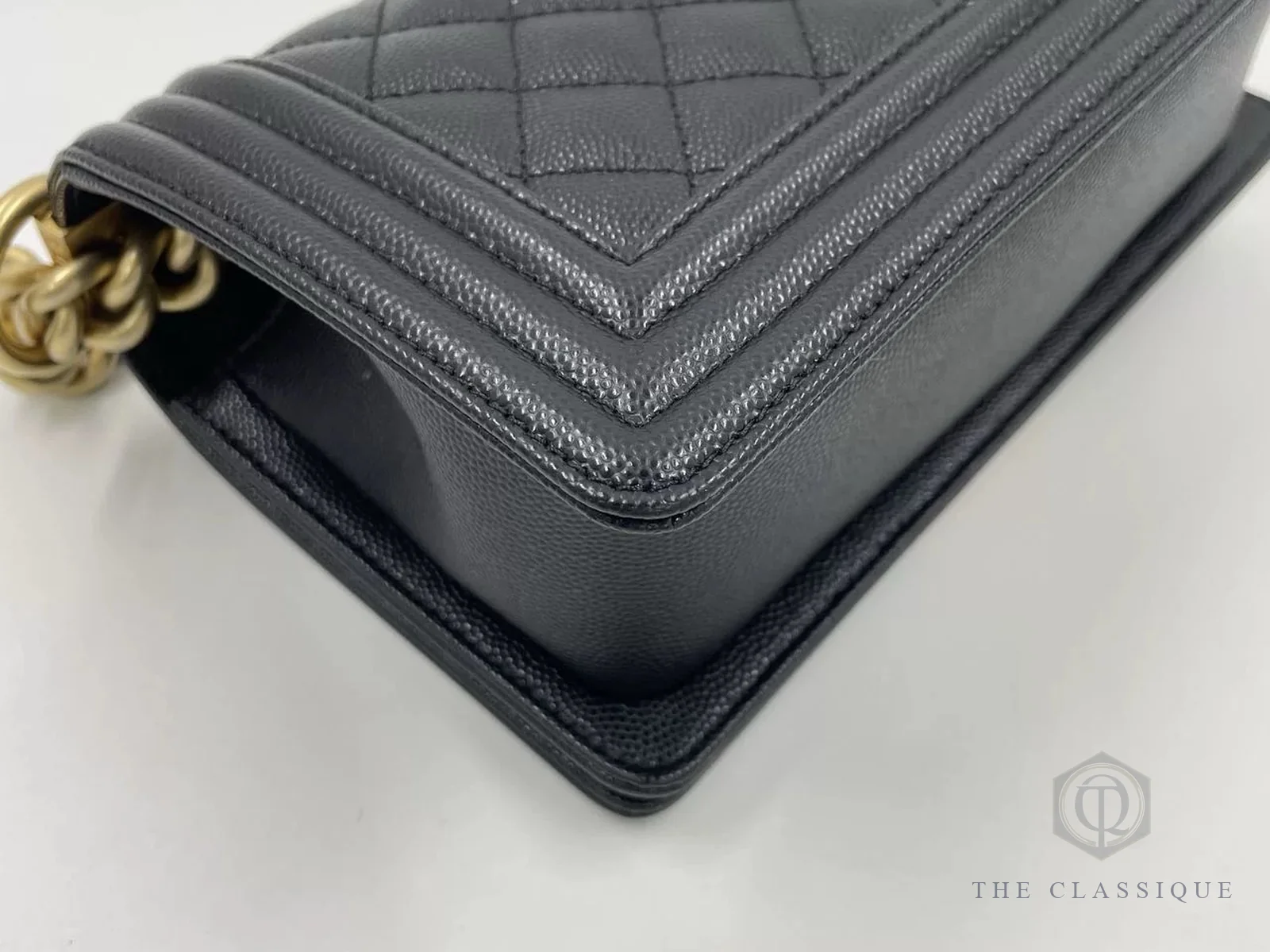 Góc túi Chanel Boy da caviar đen, thấy rõ viền da và đường chỉ quanh góc