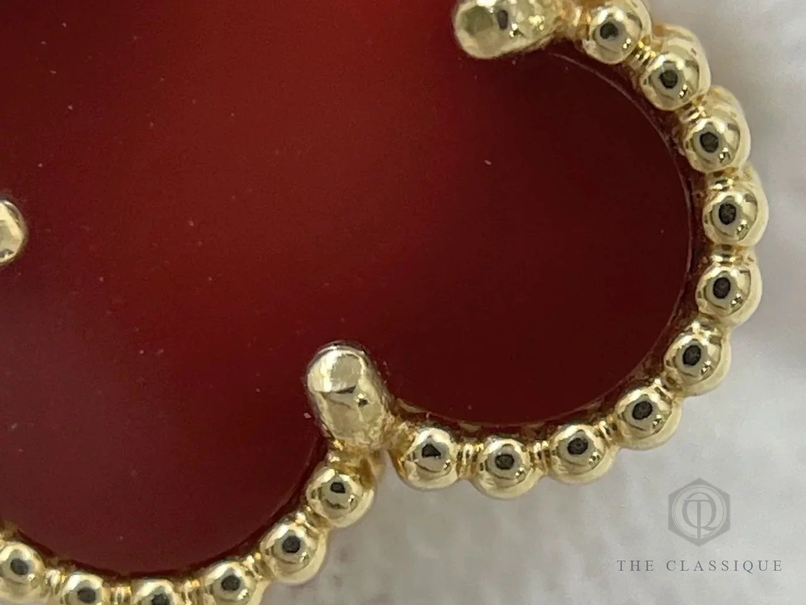 Cận cảnh mặt đá carnelian đỏ và viền hạt vàng trên hoa tai Vintage Alhambra