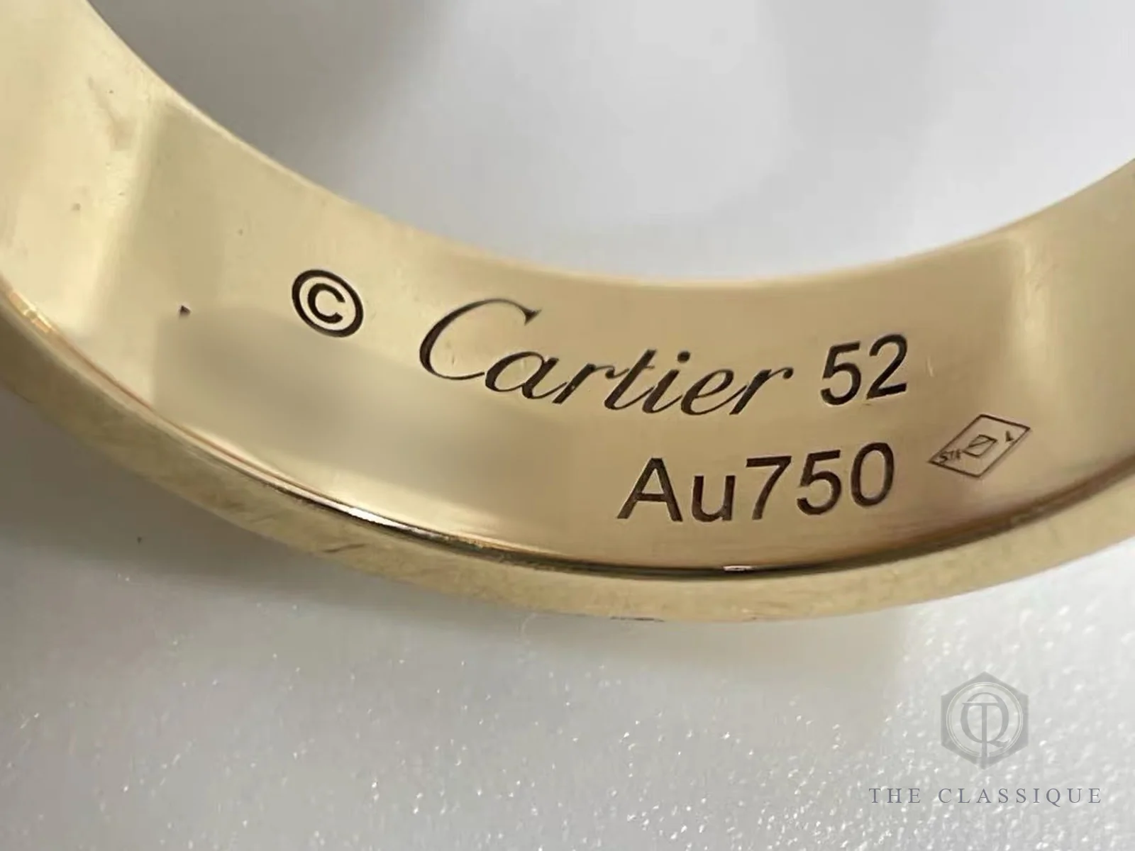 Vàng 750 là gì: ký hiệu Au750, chữ Cartier và size 52 khắc mặt trong nhẫn Cartier Love, ảnh chụp tại The Classique
