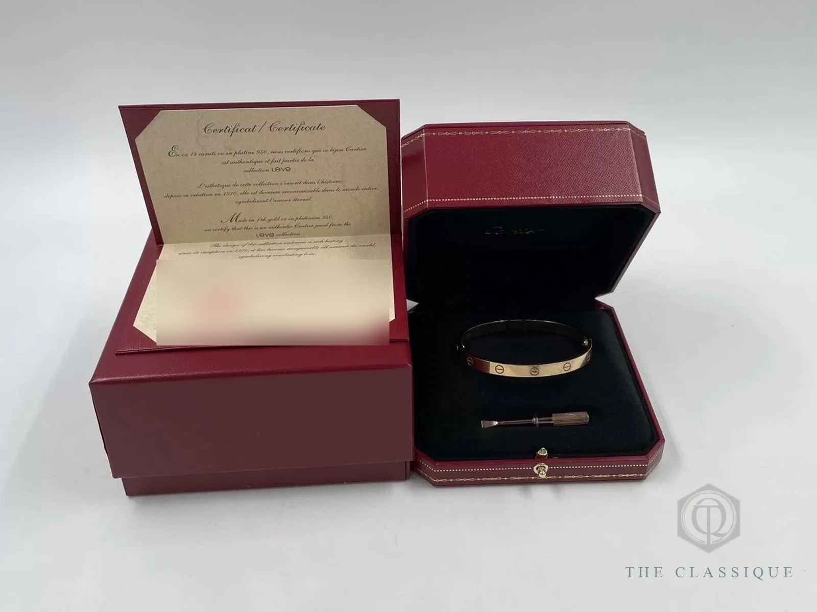 Bộ vòng Cartier Love đủ hộp đỏ, sổ chứng nhận và tua vít zin đặt cạnh nhau trên bàn thẩm định