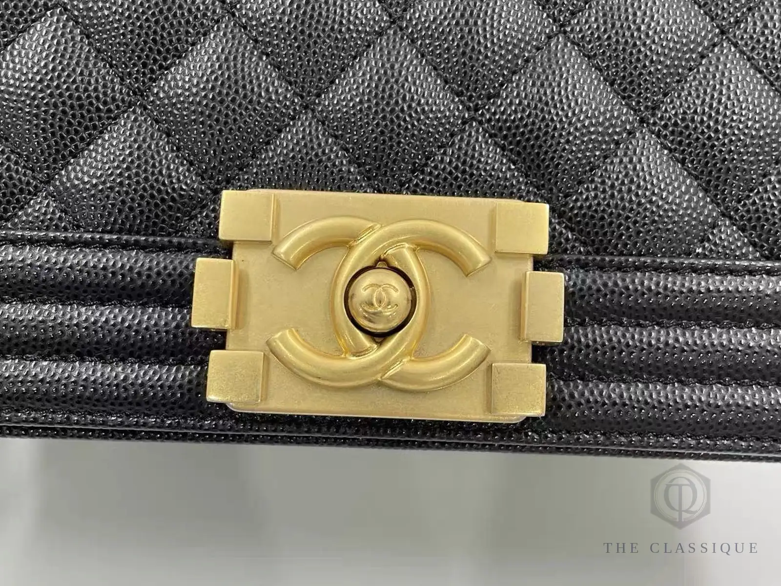 Khoá CC kiểu lồng khung trên túi Chanel, chữ C đối xứng qua tâm