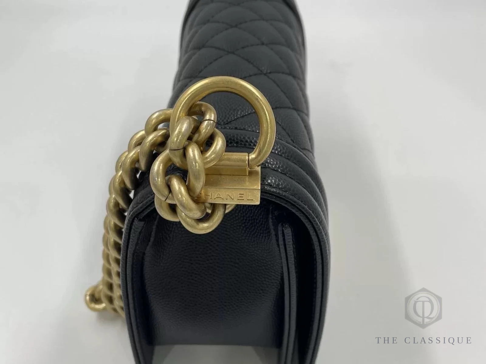 Chữ khắc CHANEL trên miếng kim loại nối dây xích, một phần bị khoen xích che khuất