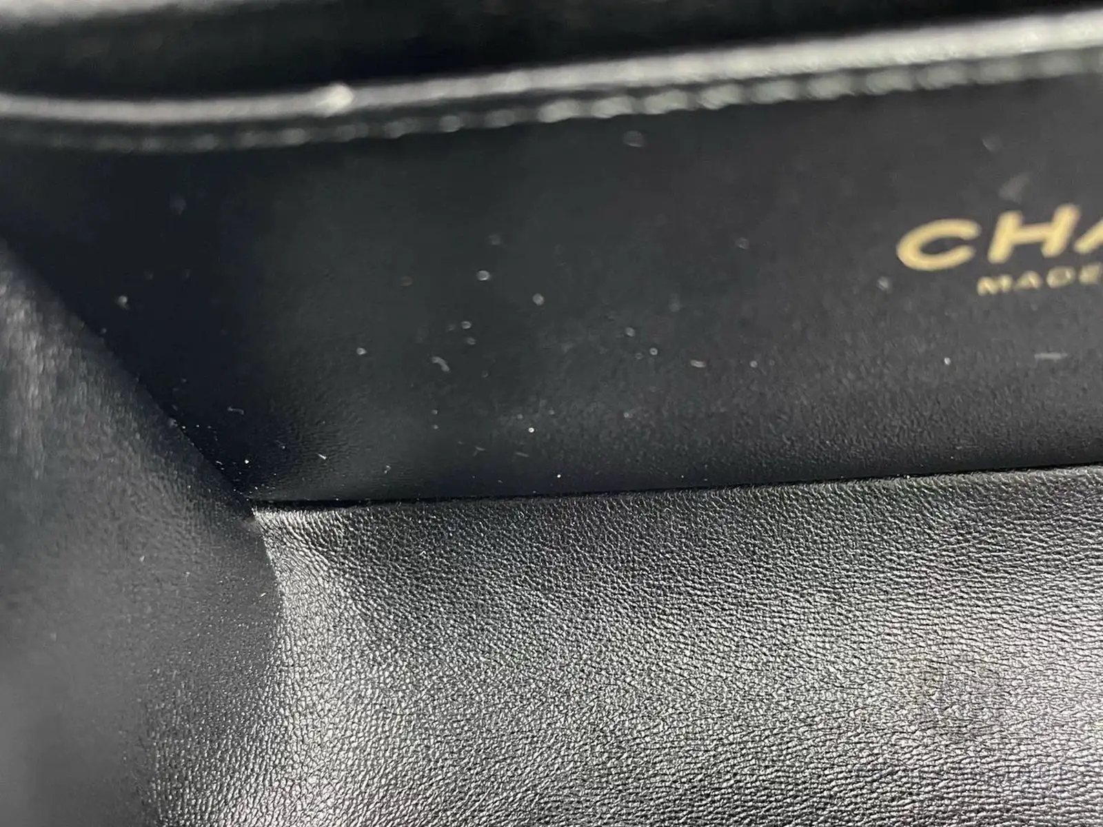 Chữ dập CHANEL MADE IN bên trong lót túi, một phần chữ nằm ngoài khung ảnh