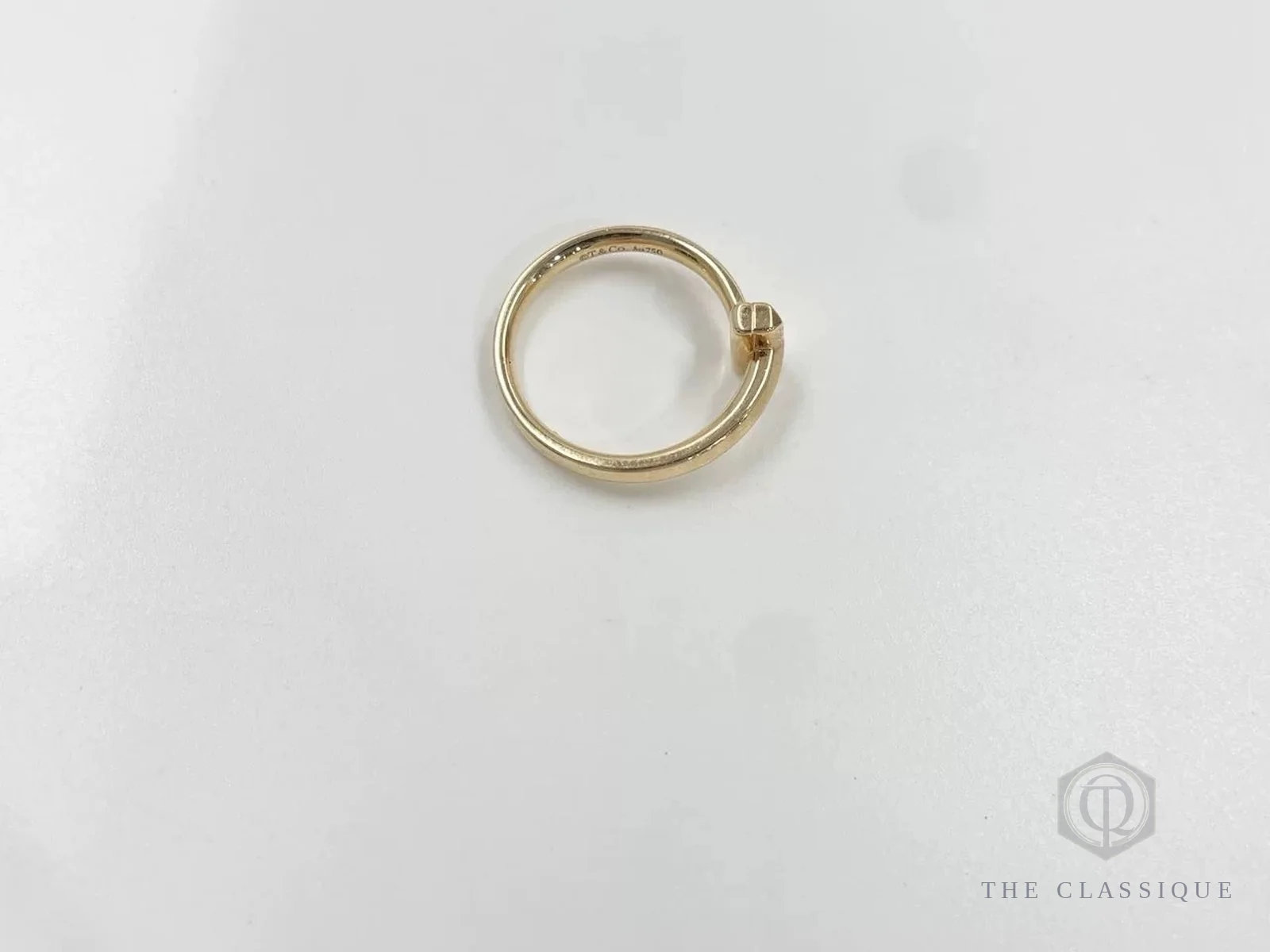 Nhẫn Tiffany T mỏng màu vàng, mặt trong chỉ có chữ khắc hãng và ký hiệu chất liệu, không có số serial riêng