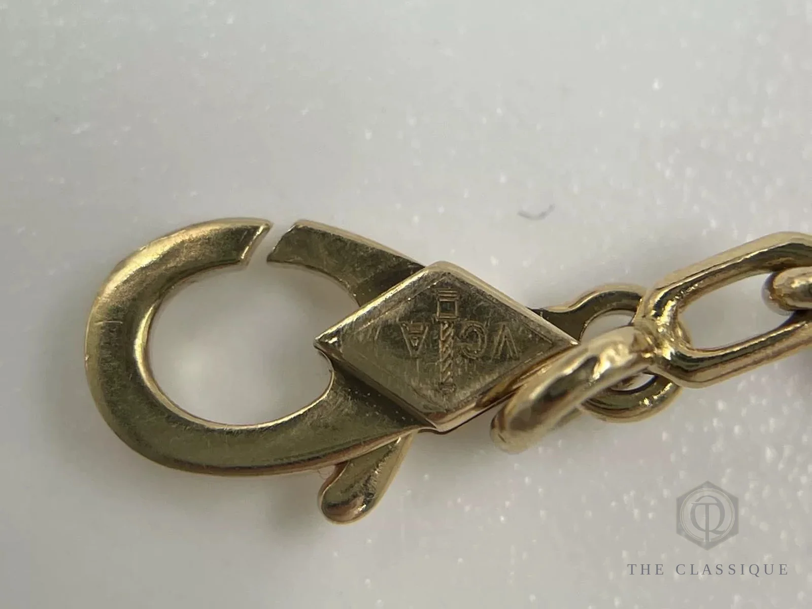 Khoá bấm khắc chữ VCA hình thoi trên một chiếc vòng tay Van Cleef thật