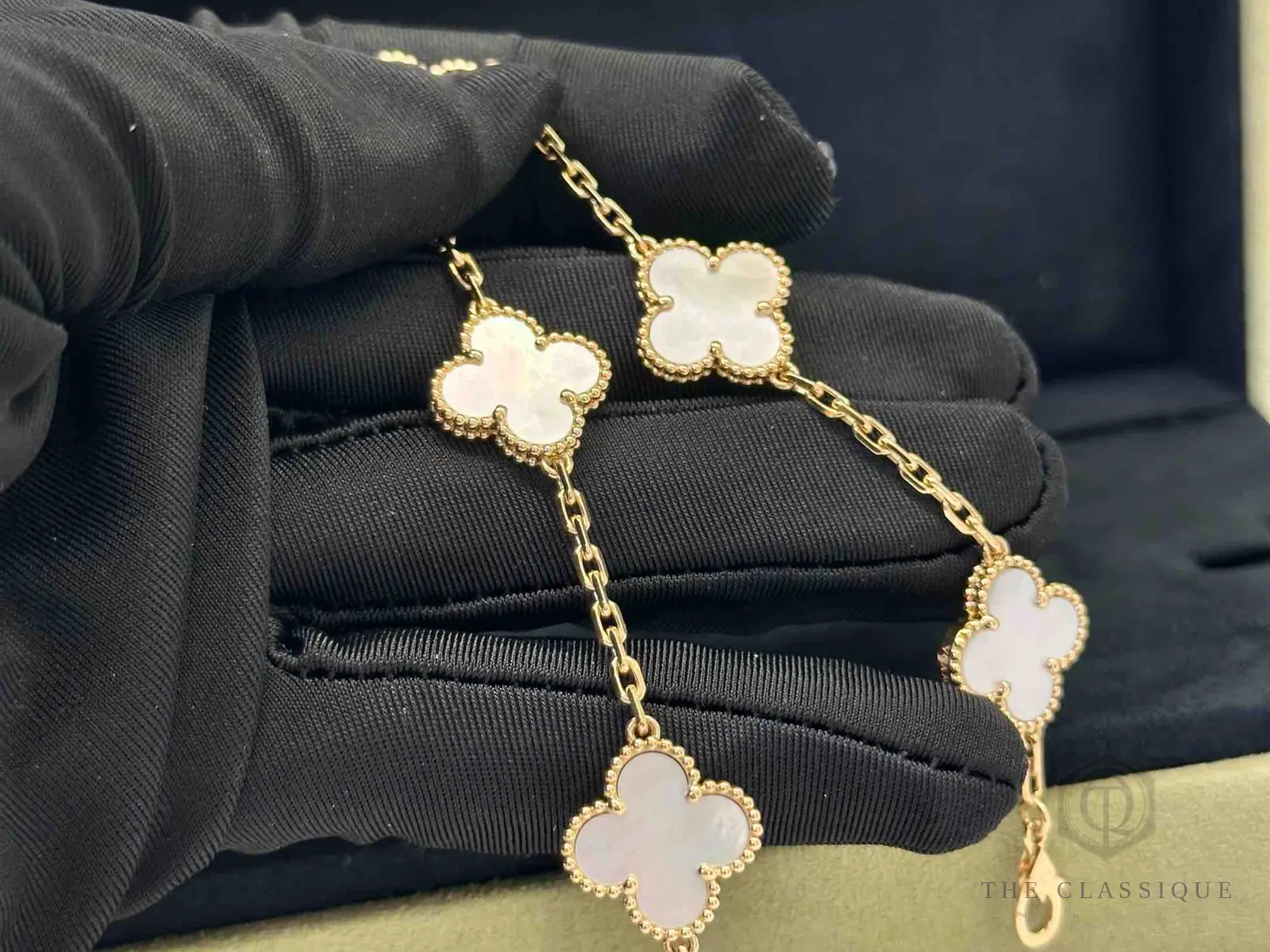 Viền hạt vàng tròn đều quanh bốn cánh hoa xà cừ trên vòng tay Van Cleef Alhambra