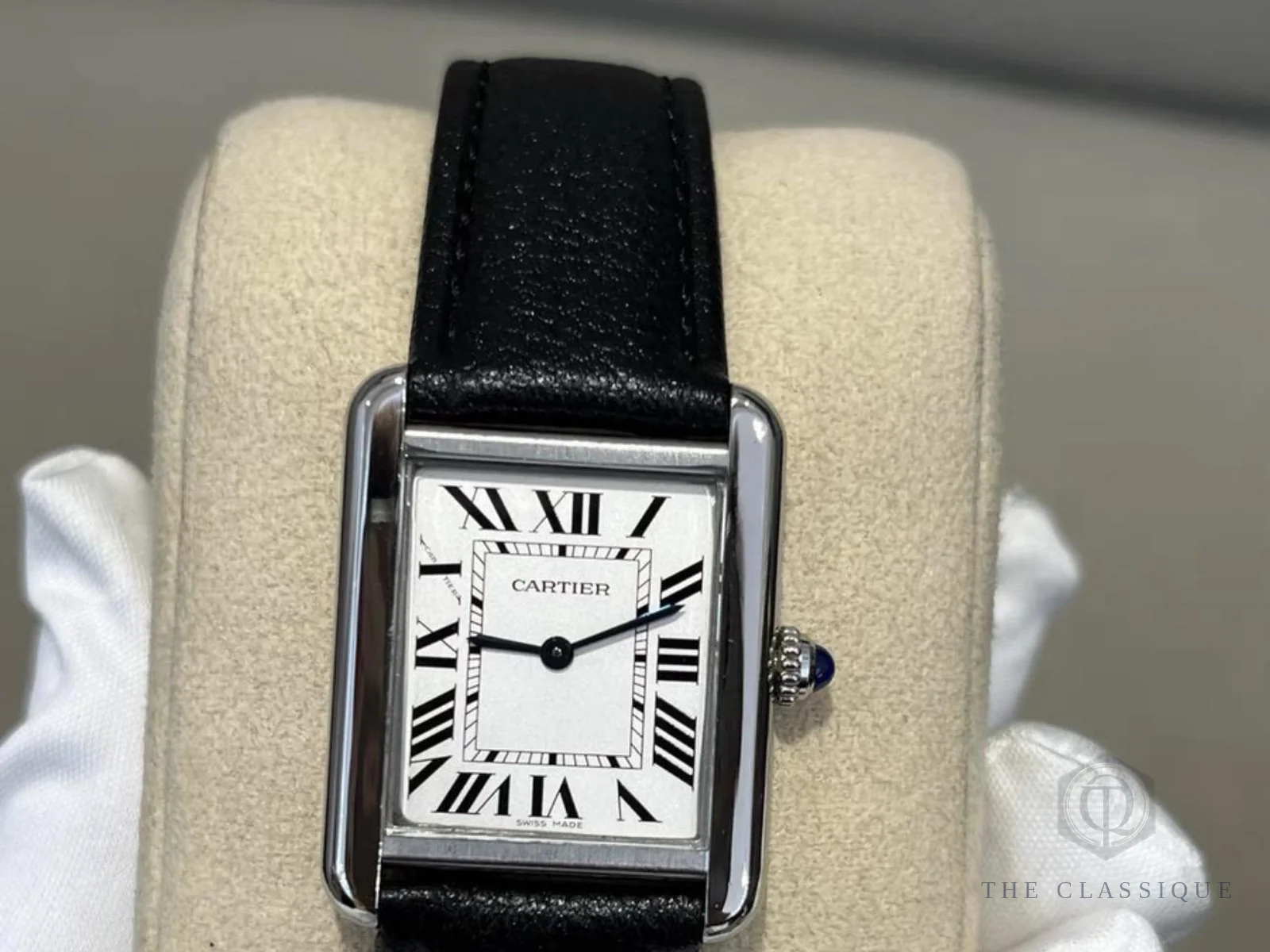 Đồng hồ Cartier Tank mặt trắng kim La Mã trên gối trưng bày, ảnh thật trước khi kiểm định đồng hồ tại The Classique