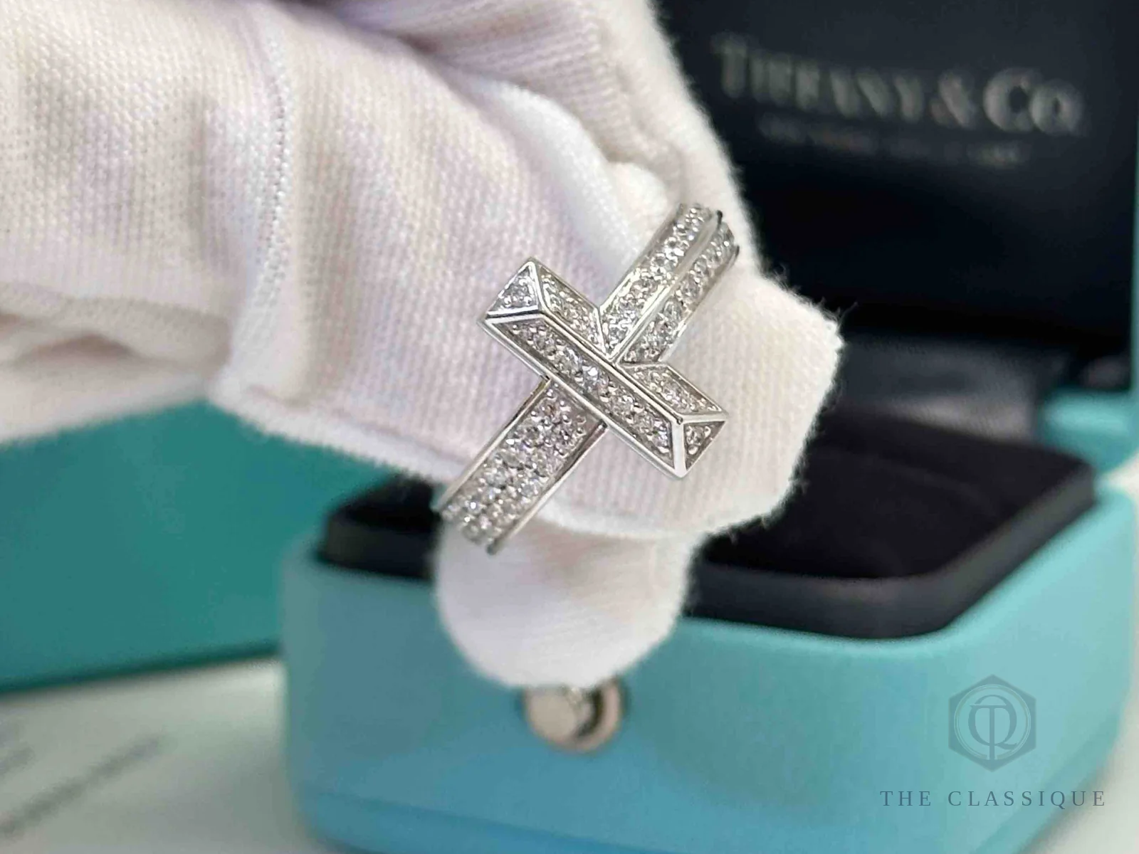 Nhẫn Tiffany & Co đính kim cương pavé hình chữ X cầm trên tay cùng hộp chính hãng khi kiểm hàng đã qua sử dụng