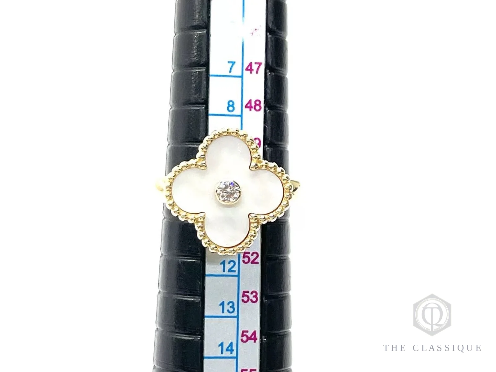 Đo size một chiếc nhẫn Van Cleef Alhambra trên que đo, dừng ở mốc size 52