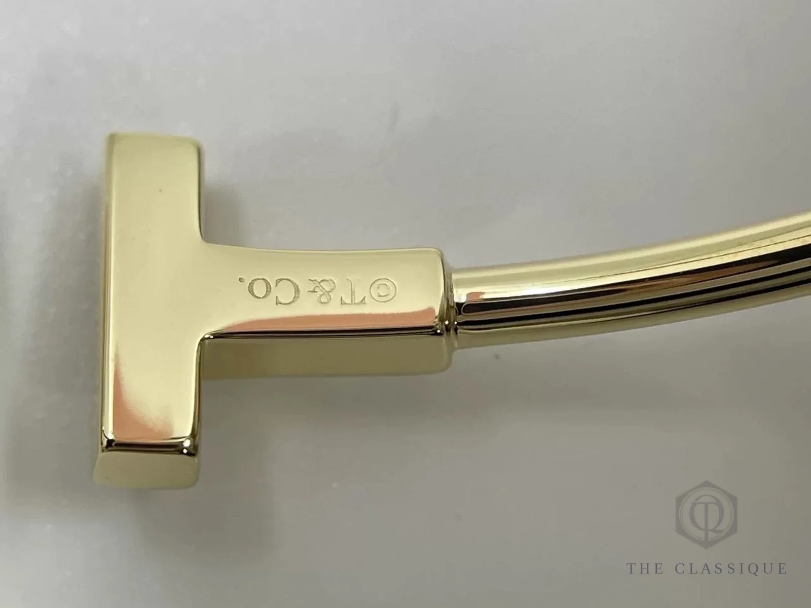 Chữ khắc T và Co trên thanh T của một chiếc vòng tay Tiffany Lock thật