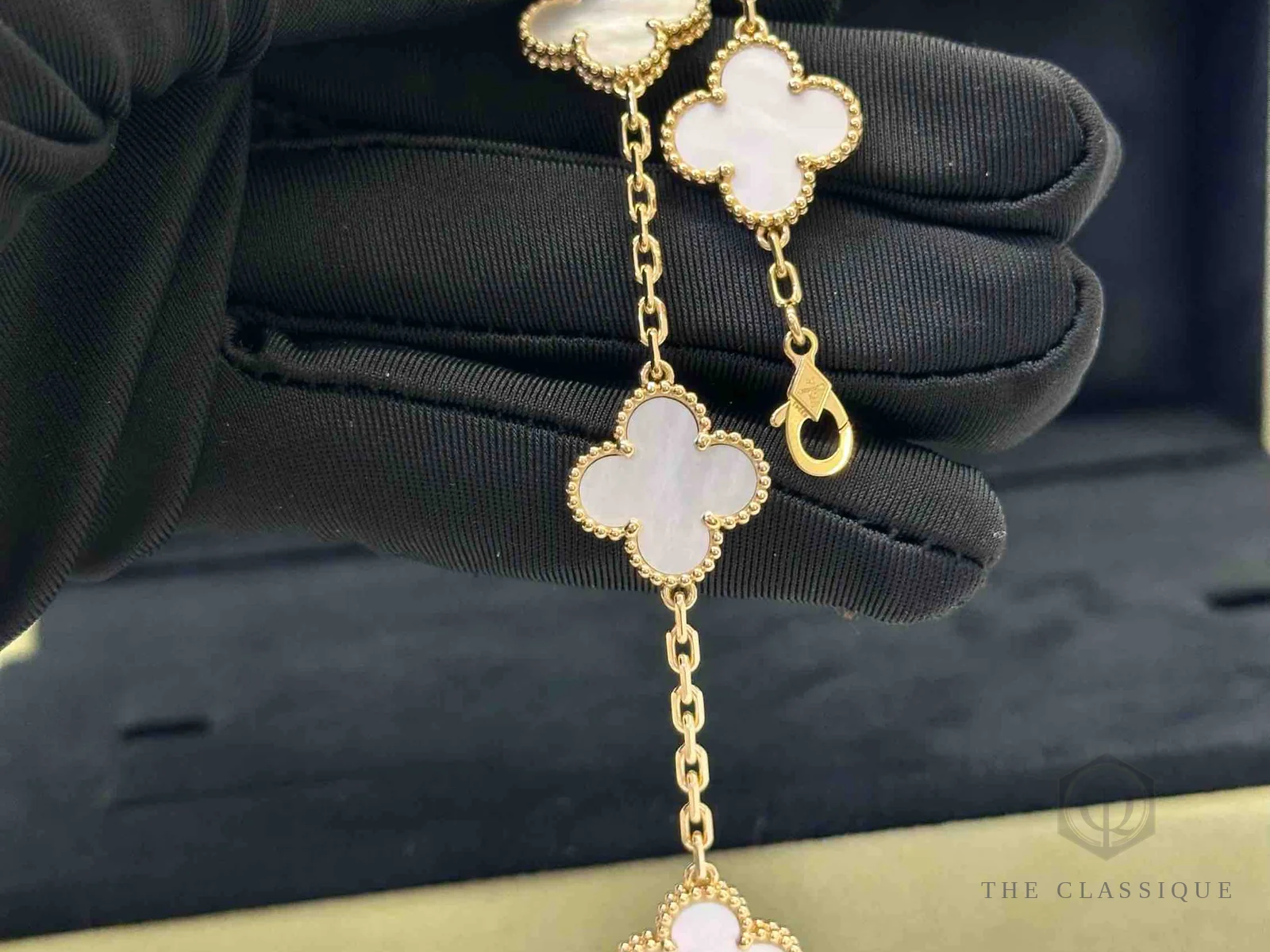 Khoá và hai lá Vintage Alhambra Van Cleef nhìn cận, hạt vàng viền quanh mặt xà cừ