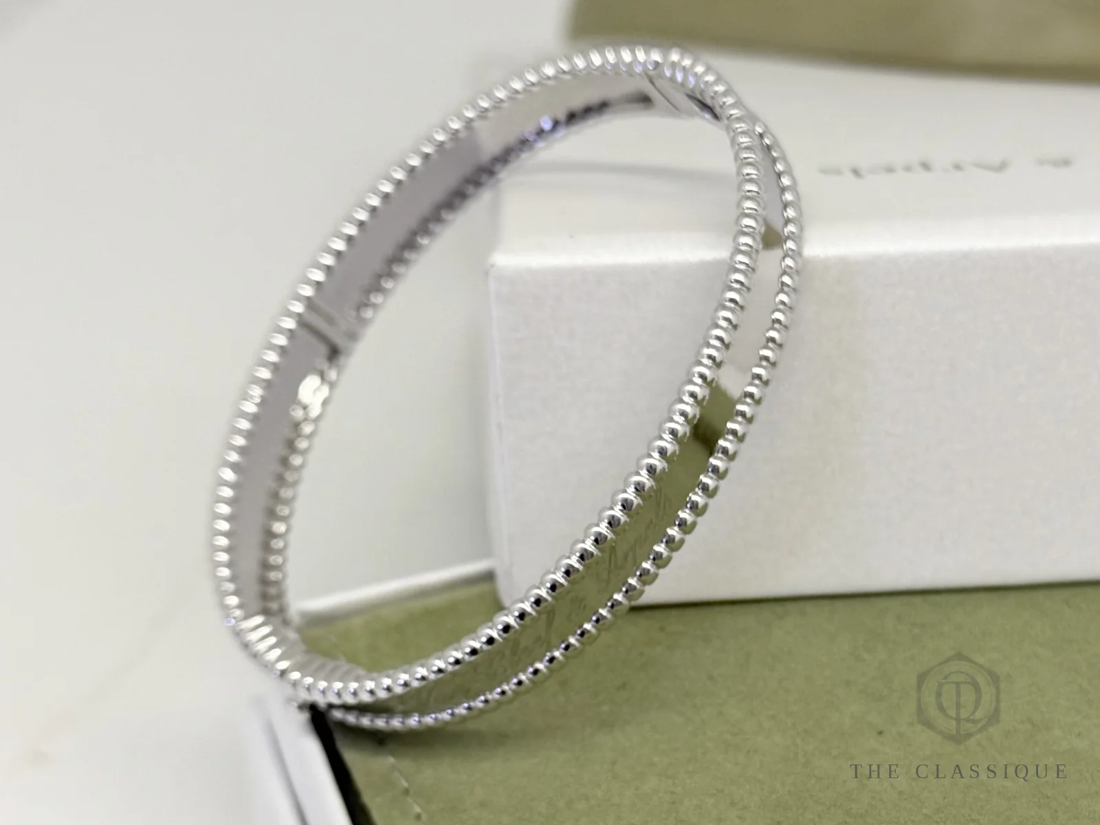 Vòng Van Cleef Perlée hạt vàng trắng nhìn từ trên xuống, thấy rõ khoá nối giữa hai đầu dây hạt
