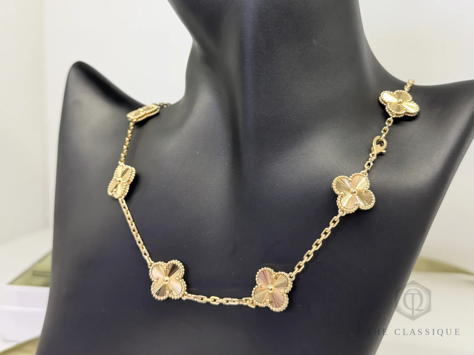 Dây chuyền Van Cleef Alhambra mười mắt hoa đeo trên cổ, vị trí khoá cài nơi khắc số serial
