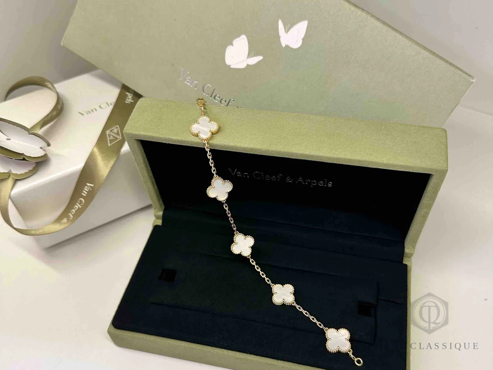 Vòng tay Van Cleef Alhambra 5 motif xà cừ trắng đặt trong hộp, cho thấy chiều dài cả sợi